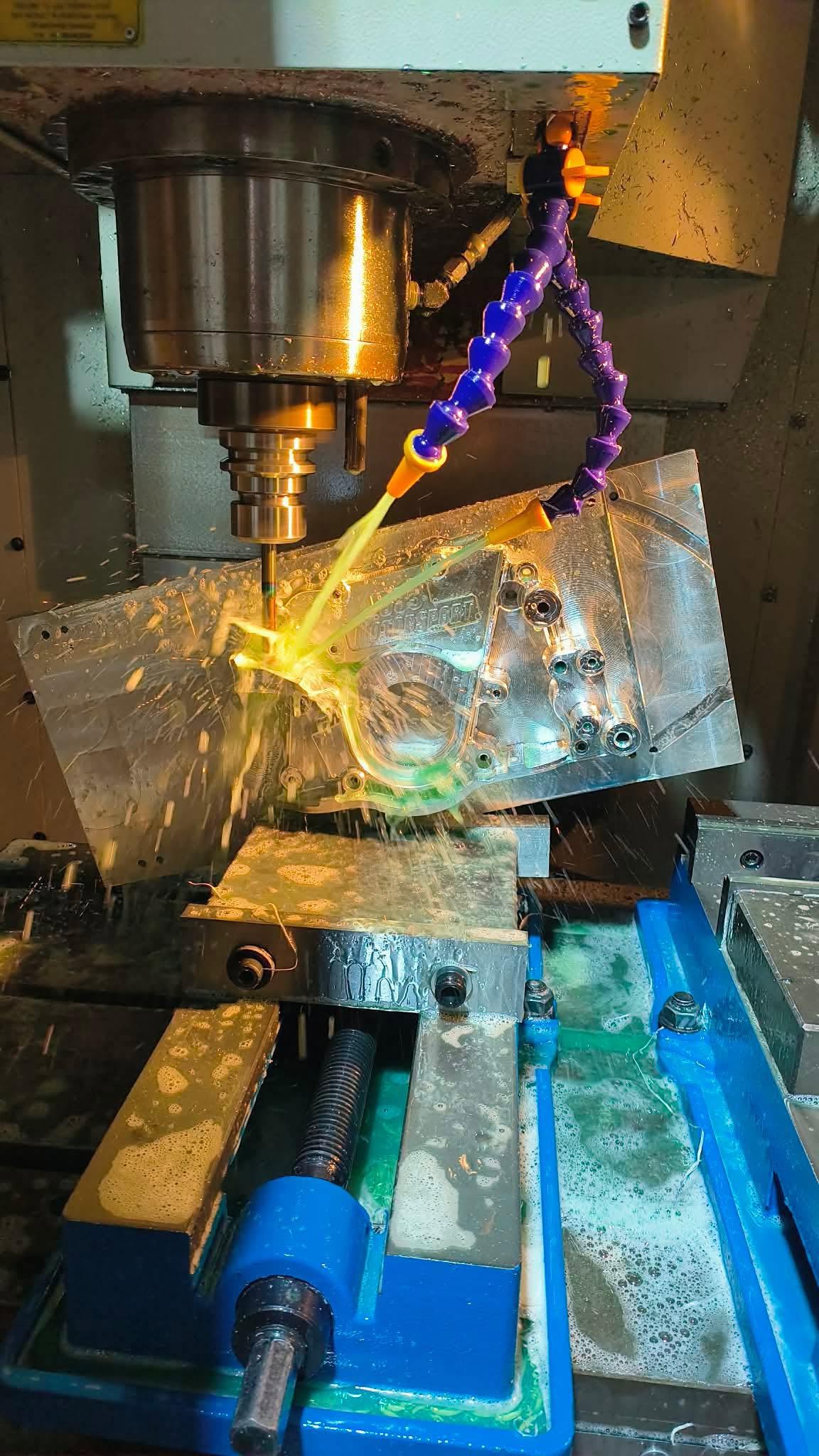 CNC machine cutting a billet aluminium part with coolant